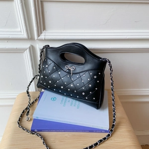 Nahaufnahme einer schwarzen Stepptasche aus Leder mit silberner Schleife und Kristallen