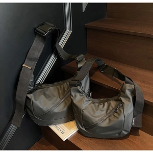 Detail of waterproof black nylon crossbody bags with diagonal zippers and wide straps