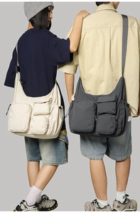 Detail of large nylon messenger bags with multiple pockets and drawstring on two models