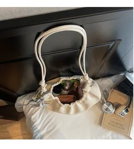 Spacious interior of beige cloud shoulder bag showing daily essentials and soft leather texture