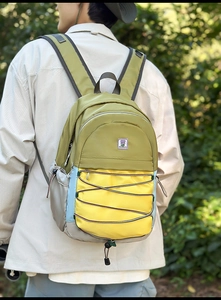 Détail d'un sac à dos en nylon multicolore avec cordon élastique et broderie florale