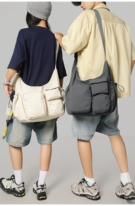 Detail view of large multi-pocket messenger bags in beige and grey utility canvas