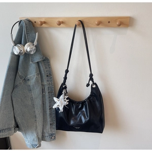 Détail du sac cabas plissé noir avec breloques étoile argentée et chien ballon stylé