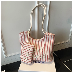 Detail of red and white striped canvas tote bag with hanging pouch and letter decor