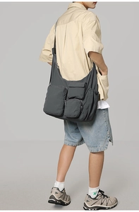 Detailed view of dark grey nylon messenger bag with multiple pockets and large capacity