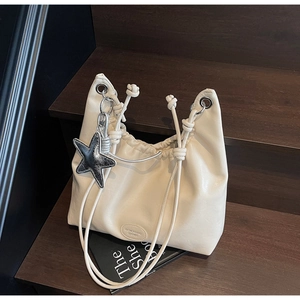 Détail du sac fourre-tout plissé blanc cassé avec breloque étoile et logo embossé