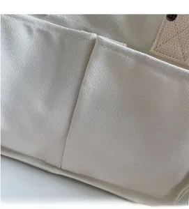 Detail of soft canvas tote showing reinforced stitching and functional double front pockets
