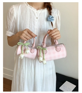 Detail of pink plaid cylinder bags in two sizes with tulip charm and bow ribbon