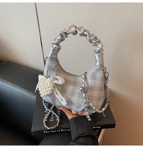 Silver-grey quilted dumpling bag with chain strap and elegant pearl bow charm detail
