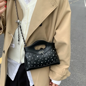 Detail der schwarzen Stepptasche mit glitzernden Strasssteinen und goldener Schleife