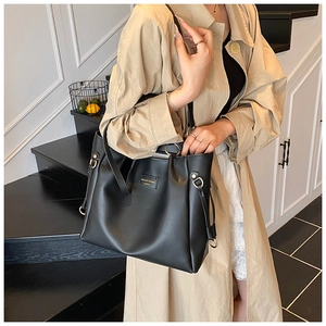 Dettaglio della borsa tote in pelle PU nera con fibbia in metallo dorato e logo
