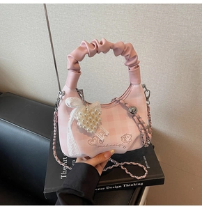 Detail of pink plaid bag with cloud handle and heart-shaped pearl pendant charm