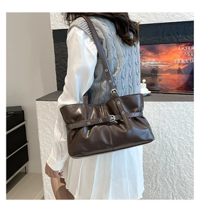 Détail du sac cabas marron foncé avec boucles rétro et bandoulière réglable sur le côté