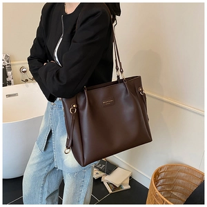 Dettaglio di una grande borsa tote in pelle marrone scuro con logo Mihao in un contesto di stile