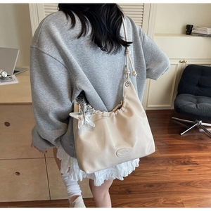 Détail du sac hobo avec bandoulière nouée et pendentif étoile argentée