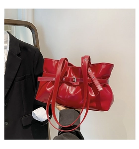 Détail du sac à bandoulière froncé rouge avec boucles réglables et texture plissée en similicuir