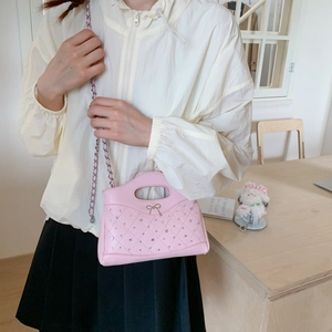 Detailansicht der rosa gesteppten Handtasche mit Strasssteinen und Metallschleife