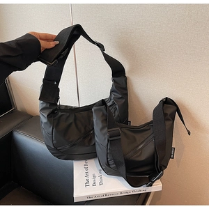 Detail shot of large and small black nylon crossbody bags with adjustable wide straps
