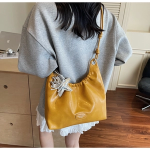 Détail du sac cabas jaune en similicuir avec breloque étoile et bandoulière réglable