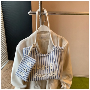 Detail of blue and white striped canvas tote with 3D embroidery and matching small pouch