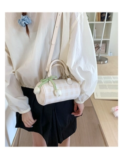 Détail du sac cylindrique à carreaux avec breloques tulipes et bandoulière réglable