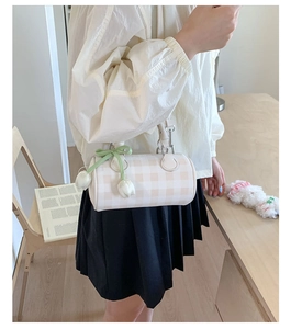 Détail du sac cylindrique à carreaux avec pendentif tulipe en tissu et anneaux métalliques