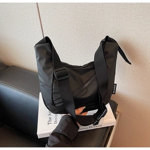 Detail of black nylon shoulder bag with adjustable wide strap and plastic buckle