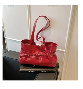 Vue détaillée d'un sac cabas en cuir rouge brillant avec boucle argentée et ceinture