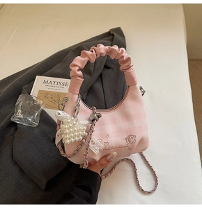 Pink checkered dumpling bag with ruffled handle, heart pearl charm, and chain strap detail