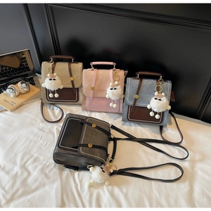 Detailed view of four retro square handbags in various colors with plush doll accessories
