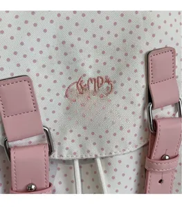 Detail of pink polka dot canvas backpack with embroidered MD Hello logo and leather strap