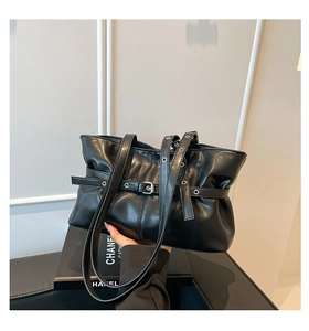 Détail du sac à main noir plissé en cuir avec boucle métallique et texture souple chic