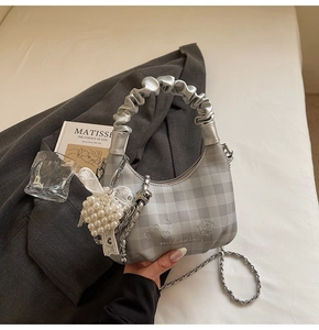 Detailed top view of grey plaid crescent bag with heart embroidery and pearl charm