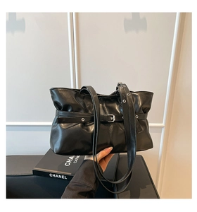 Détail du sac cabas noir en cuir synthétique brillant avec plis et boucle argentée
