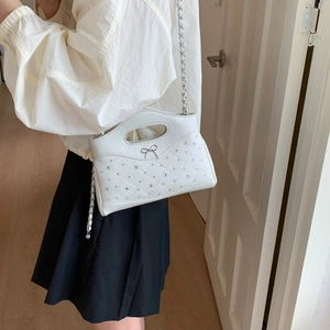Detailansicht der weißen Stepptasche mit Strasssteinen und silberner Gliederkette