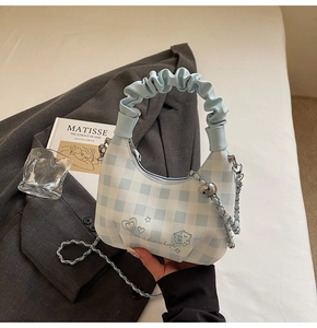 Detail of blue gingham handbag with cloud-shaped pleated handle and chain strap