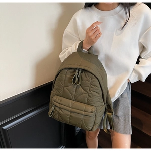 Detail of army green quilted backpack showing rhombus pattern and nylon texture