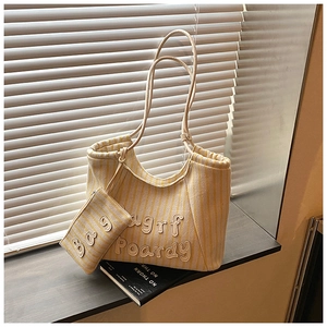 Detailed embroidery on striped canvas tote bag with matching zipper coin purse detail