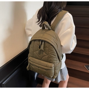 Close-up of army green quilted backpack showing wave patterns and soft nylon material
