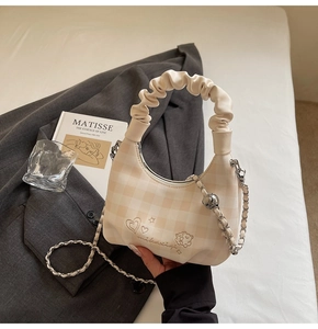 Detail of beige plaid hobo bag with cloud-like ruched handle and heart embroidery