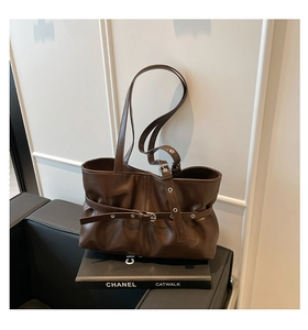 Détail du sac cabas en cuir marron foncé avec sangles à œillets et plis naturels