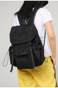 Detail of black outdoor backpack with buckle closure and adjustable side drawstrings
