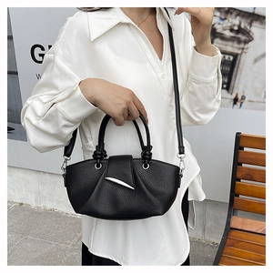 Close-up of black lychee grain leather pleats and silver metallic hardware on handbag