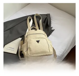 Detailed view of beige backpack with wave-textured surface and patterned woven strap