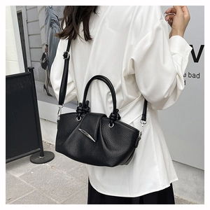Detail of black lychee grain leather tote bag with pleated cloud design and silver metal clasp