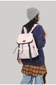 Pink hiking backpack detail with black adjustable straps and drawstring closure system