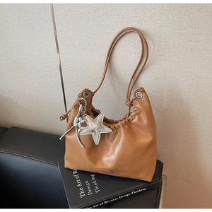 Détail du sac cabas marron caramel avec plis à cordon et pendentif étoile argentée