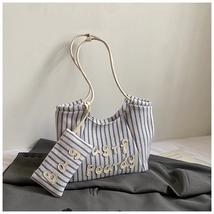 Detailed view of striped canvas tote bag set with embroidered logo and blue white pattern