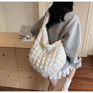 Detailed view of the large white quilted puffy shoulder bag texture and stitching