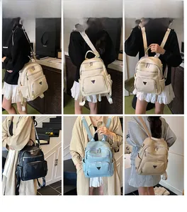 Detail view of stylish small backpacks in four colors showing zippers and metal logo